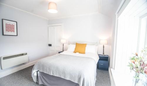 um quarto branco com uma cama e uma janela em One Oban em Oban