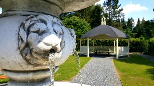 a fountain with a lion head in a park at Penzion Střela Krucemburk in Křížová