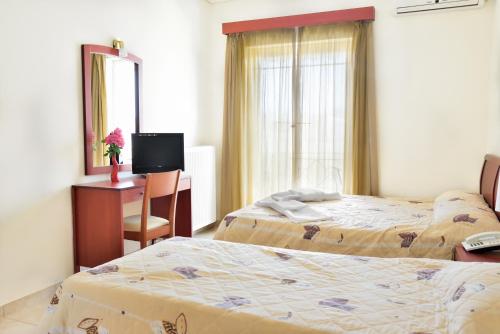 a bedroom with two beds and a desk and a mirror at Evia Studios in Loutra Edipsou