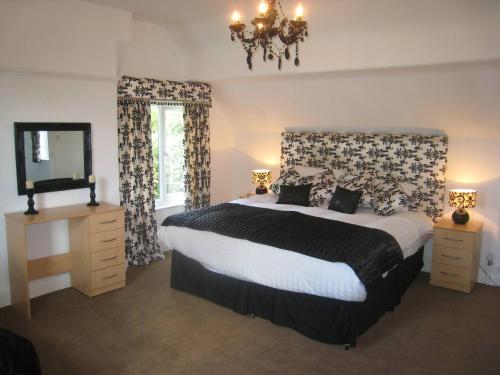 a bedroom with a bed and a mirror and a television at Arden Hill Farmhouse - Hot Tub, Snooker Table, Sleeps 16 in Stratford-upon-Avon