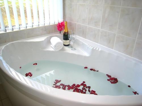 a bath tub with roses on the inside of it at Arden Hill Farmhouse - Hot Tub, Snooker Table, Sleeps 16 in Stratford-upon-Avon