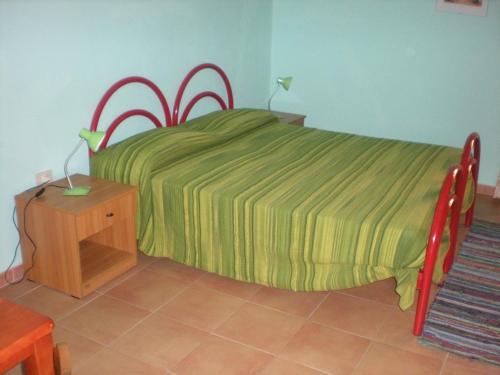 een slaapkamer met een bed met een groen dekbed bij B&B Novalis in Brattirò
