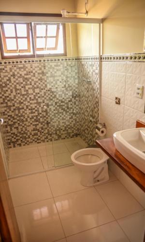 a bathroom with a toilet and a sink at Pousada do Tigrinho in São Bento do Sapucaí