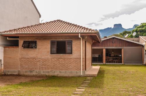 a brick house with a porch and a garage at Pousada do Tigrinho in São Bento do Sapucaí