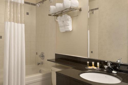 a bathroom with a sink and a toilet and a tub at Nova Inn Yellowknife in Yellowknife