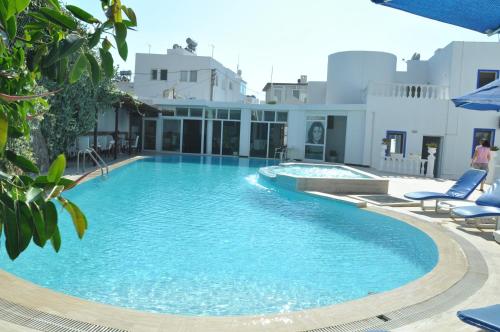 a swimming pool with blue chairs and a building at Bodrum Blu Hotel in Bodrum City
