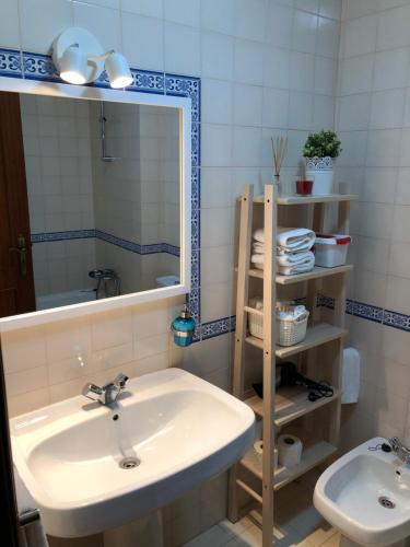 a bathroom with a sink and a mirror and a toilet at Apartamento - Casas dos Infantes in Caldas da Rainha