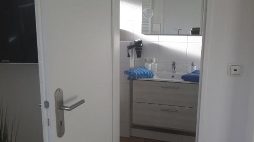 Baño blanco con lavabo y espejo en " noch ne Brise" en Büsum