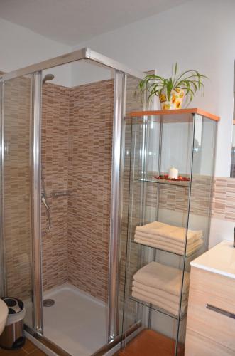 een douche met een glazen douchecabine met handdoeken bij Casa de la playa in Punta de Mujeres