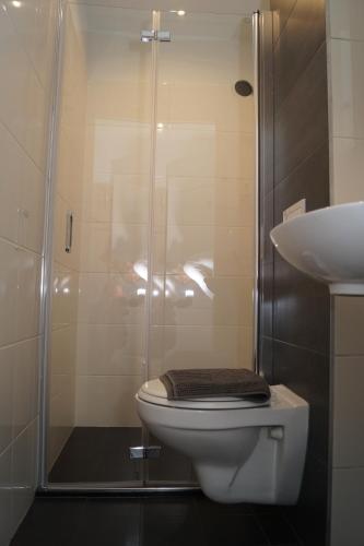 a bathroom with a shower with a toilet and a sink at JJ Hotel Hannover-City-Pension in Hannover