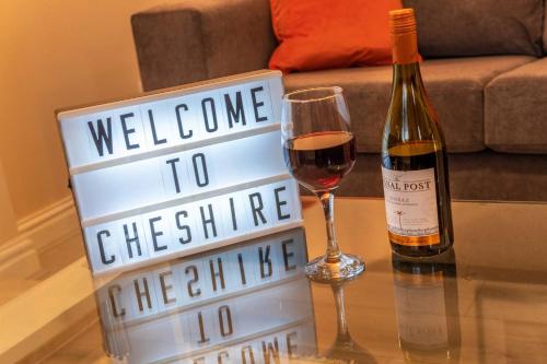 eine Flasche Wein und ein Weinkennzeichen auf dem Tisch in der Unterkunft Cheshire House - In The Heart Of Cheshire - FREE Parking - Working Professionals, Contractors, Families - Winsford in Winsford