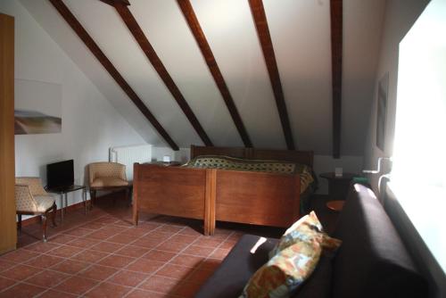 a living room with a bed and a couch at Punta Del Corno Agriturismo in San Felice del Benaco
