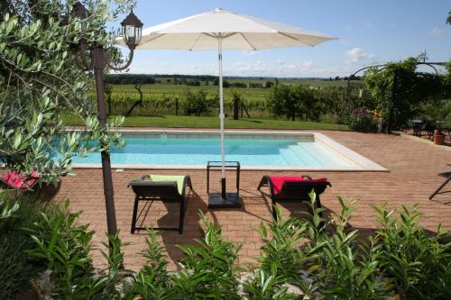 une piscine avec deux chaises et un parasol dans l'établissement Au Mas du Soleil, à Senouillac