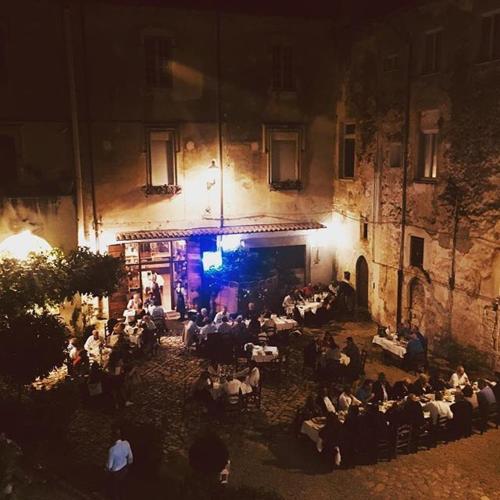 a group of people sitting in front of a building at night at Bed And Breakfast Mblò in Fondi