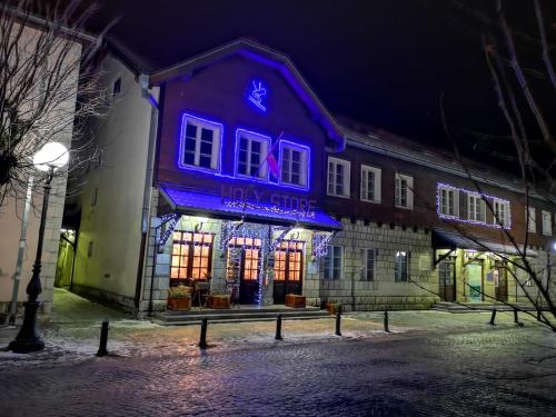 a building with a blue lit up sign on it at Apartments & Rooms Bojic in Kolašin