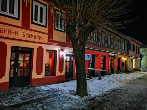 a tree in front of a building at night at Apartments & Rooms Bojic in Kolašin