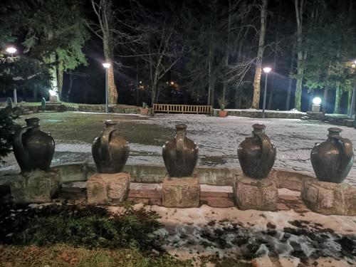 a row of vases sitting on a wall at night at Apartments & Rooms Bojic in Kolašin