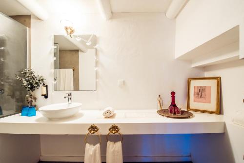 a white bathroom with a sink and a mirror at Terra do Sempre in Grândola