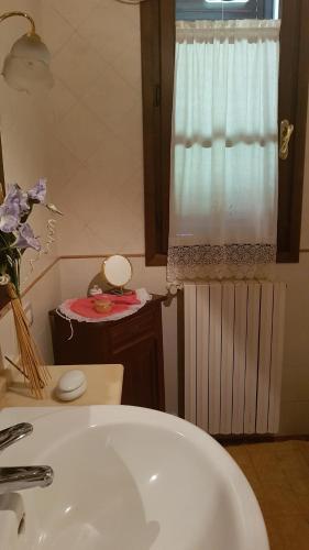 a bathroom with a white sink and a window at Camere Montalbano in San Miniato