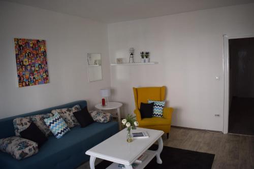 a living room with a blue couch and a yellow chair at Apartment Optimist/Downtown in Split