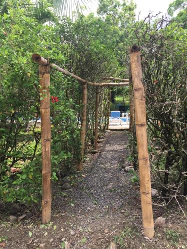 a wooden fence with a path in the woods at Mal Pais Surf Camp in Santa Teresa Beach