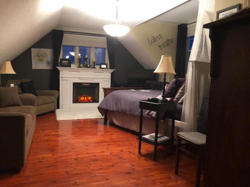a bedroom with a bed and a fireplace at By The Sea Tourist Home in Bonavista