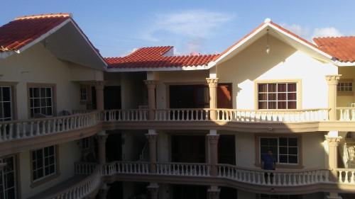a large white house with a balcony at Rolando share apart in Punta Cana