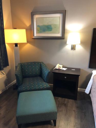 a room with a couch and a chair in a hotel room at Deerfield Inn and Suites - Fairview in Fairview