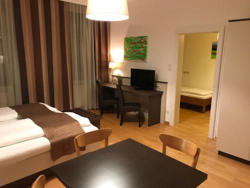 a hotel room with a bed and a table and a desk at Gasthof Schwabl Wirt in Vienna