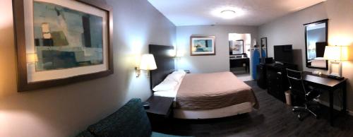 a hotel room with a bed and a desk at Deerfield Inn and Suites - Fairview in Fairview
