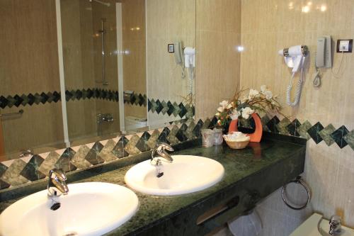 a bathroom with two sinks and a large mirror at La Familia Gallo Rojo in El Campello