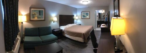 a hotel room with a bed and a chair at Deerfield Inn and Suites - Fairview in Fairview