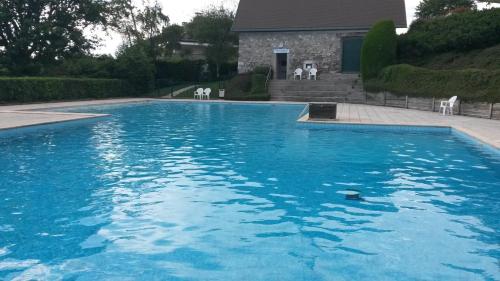une grande piscine bleue devant une maison dans l'établissement le havre de paix, à Annecy