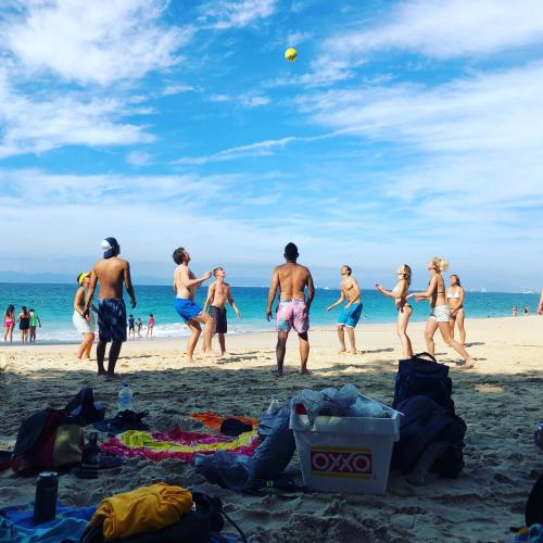 a group of people playing volley ball on the beach at Casa Kraken Hostel in Puerto Vallarta
