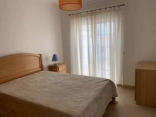 a bedroom with a bed and a large window at Beachouse Algarve in Manta Rota
