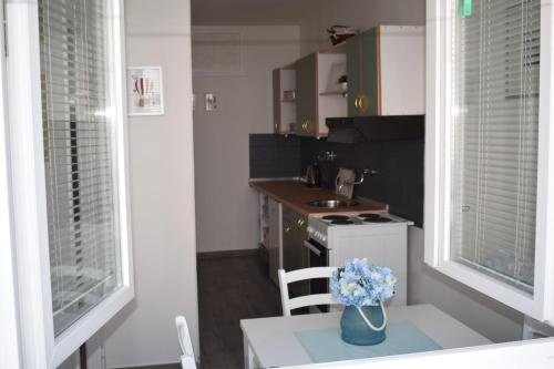 a kitchen with a vase of blue flowers on a table at Apartment Optimist/Downtown in Split