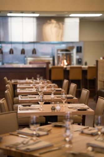 a row of tables and chairs with wine glasses on them at NOPSI Hotel New Orleans in New Orleans