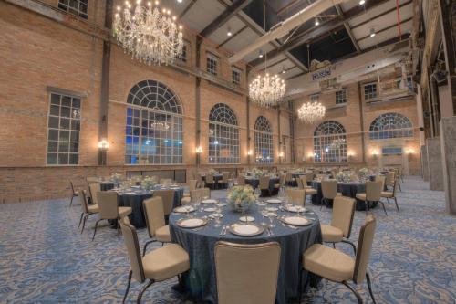 a banquet hall with tables and chairs and chandeliers at NOPSI Hotel New Orleans in New Orleans
