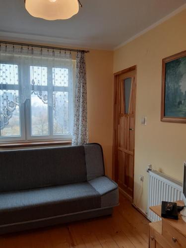 a living room with a couch and a window at Willa Marylka in Piwniczna