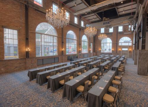 a row of tables and chairs in a room with windows at NOPSI Hotel New Orleans in New Orleans