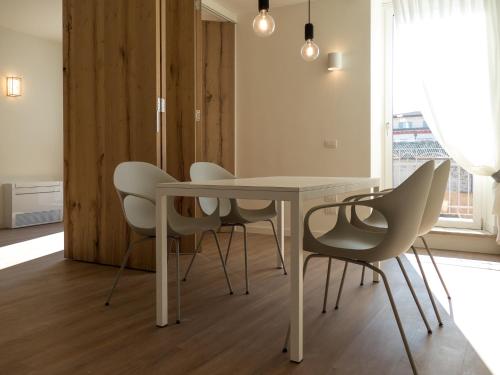 a dining room with a white table and chairs at Porto Vecchio Appartamenti in Lazise