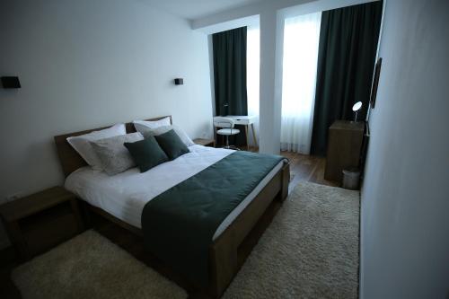 a bedroom with a large bed with pillows at Pristina Downtown Apartment in Prishtinë