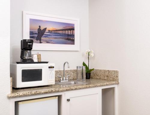 a kitchen counter with a microwave and a sink at Beachfront Inn and Suites at Dana Point in Capistrano Beach