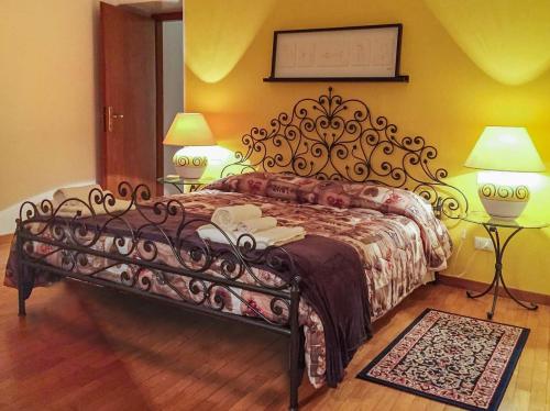 a bed in a bedroom with two lamps and two tables at Moro Dal Castel - Appartamento Al Castel in Castelnuovo del Garda