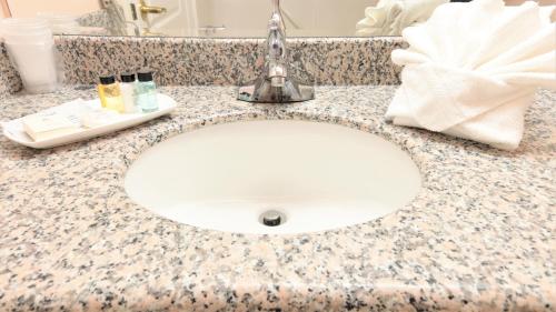 a bathroom counter with a white sink with a towel at Crystal Star Inn Edmonton Airport with free shuttle to and from Airport in Leduc
