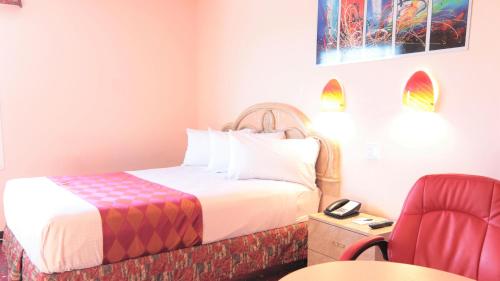 a hotel room with a bed and a red chair at Crystal Star Inn Edmonton Airport with free shuttle to and from Airport in Leduc