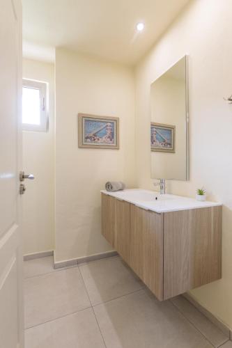 a bathroom with a sink and a mirror at Coral Luxury Villas in Lozenets