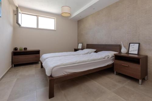 a bedroom with a large bed and two night stands at Coral Luxury Villas in Lozenets