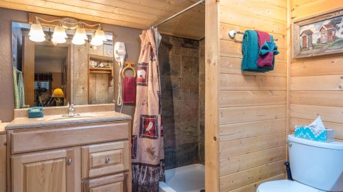 a bathroom with a toilet and a sink at Whispering Pine Cabins in Ruidoso