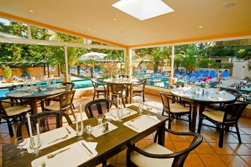 a restaurant with tables and chairs and a pool at Apartamentos da Balaia in Albufeira